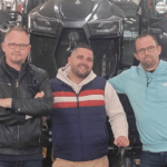 Trois hommes devant un tracteur
