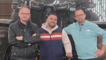 Trois hommes devant un tracteur