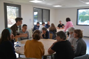 Des personnes dans une salle de réunion autour de tables rondes