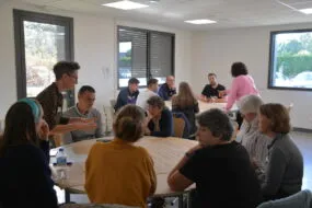 Des personnes dans une salle de réunion autour de tables rondes
