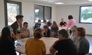 Des personnes dans une salle de réunion autour de tables rondes