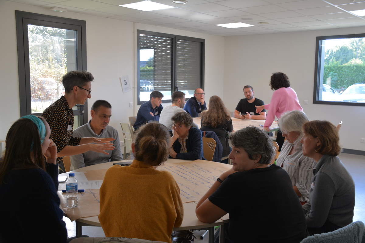 Des personnes dans une salle de réunion autour de tables rondes - Illustration Les métiers agricoles en débat