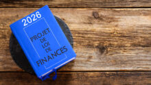 Un livre intitulé projet de loi de finances 2026 posé sur une table en bois
