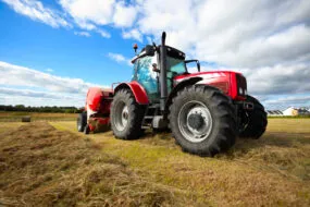 Un tracteur au travail dans un champ avec une presse