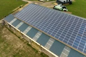 Vue aérienne d'une couverture de bâtiment agricole recouverte de panneaux photovoltaïques