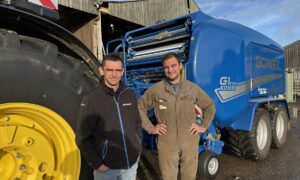 Deux personnes devant un tracteur et une presse pour round baler
