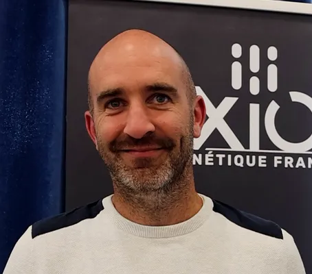 Portrait de Mathieu Couillard devant une affiche Axiom