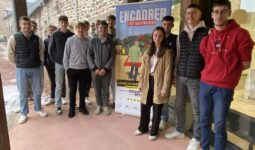 des jeunes étudiants autour d'un panneau "Encadrer, c'est aussi protéger"