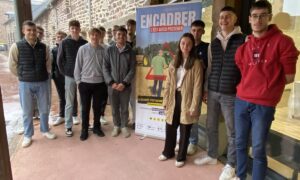 des jeunes étudiants autour d'un panneau "Encadrer, c'est aussi protéger"