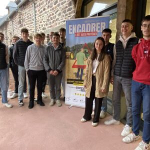 des jeunes étudiants autour d'un panneau "Encadrer, c'est aussi protéger"