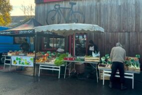 Étal de légumes sur un marché avec des personnes