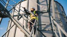 Un homme en tenue de sécurité sur les escaliers d'un silo à grain