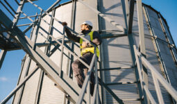 Un homme en tenue de sécurité sur les escaliers d'un silo à grain