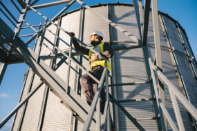 Un homme en tenue de sécurité sur les escaliers d'un silo à grain