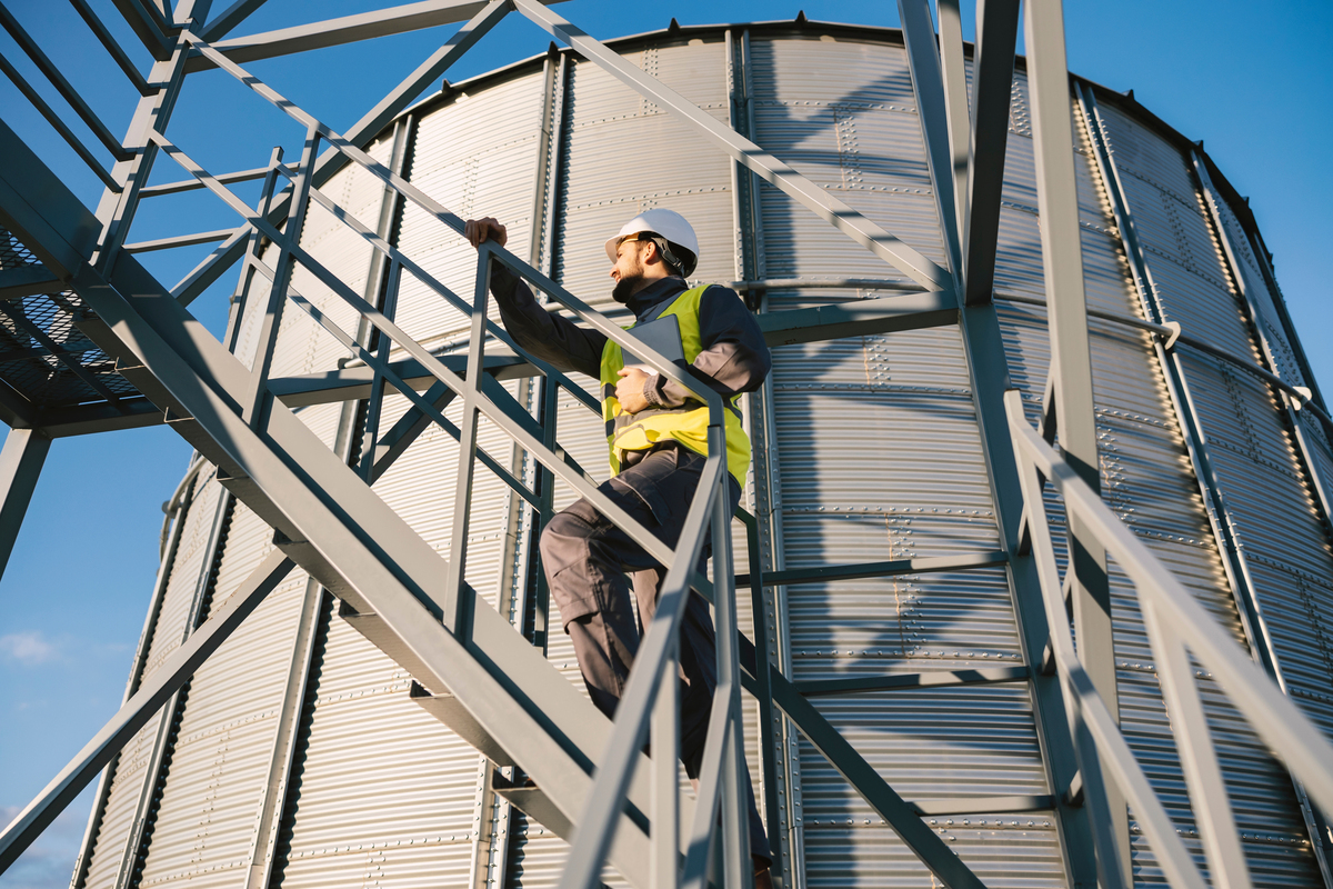Un homme en tenue de sécurité sur les escaliers d'un silo à grain - Illustration Sécurité en élevage : ensemble, protégeons nos équipes et nos exploitations