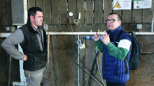 Deux hommes en train de discuter dans un bâtiment d'élevage de vaches laitières