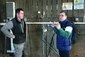 Deux hommes en train de discuter dans un bâtiment d'élevage de vaches laitières