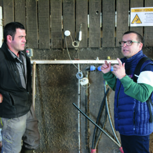 Deux hommes en train de discuter dans un bâtiment d'élevage de vaches laitières