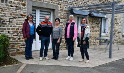 Des personnes devant une maison d'habitation en vieilles pierres