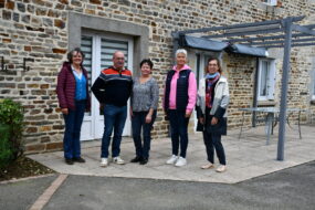 Des personnes devant une maison d'habitation en vieilles pierres