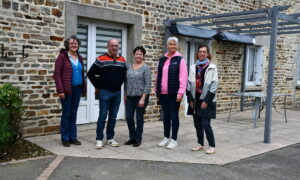 Des personnes devant une maison d'habitation en vieilles pierres