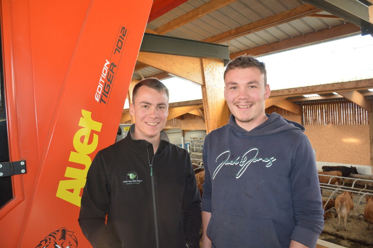 2 hommes dans un bâtiment d'élevage de vaches laitières