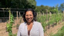 Une femme souriante dans un champ de vignes