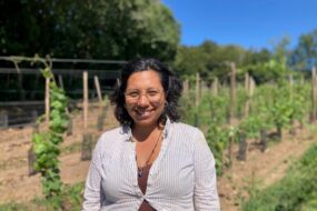Une femme souriante dans un champ de vignes