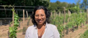 Une femme souriante dans un champ de vignes