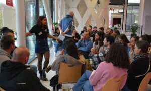 un groupe de personnes face à une exposante sur un salon