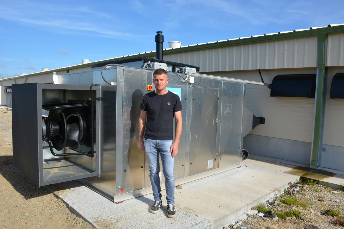 Un homme devant un système de chauffage d'un bâtiment d'élevage de volailles - Illustration Un poulailler neuf avec un chauffage innovant