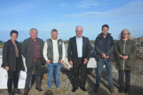 Des personnes devant le chantier de construction d'une porcherie