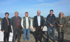 Des personnes devant le chantier de construction d'une porcherie