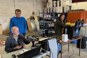 Deux hommes et une femme réalisant des analyses de fourages grâce à des appareils