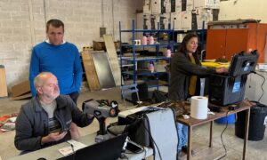 Deux hommes et une femme réalisant des analyses de fourages grâce à des appareils