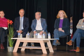 Cinq personnes à une tribune