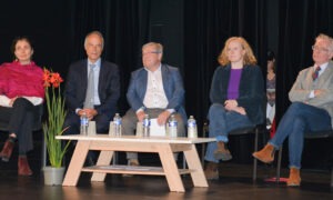 Cinq personnes à une tribune