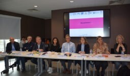 Des personnes à une tribune avec un écran derrère