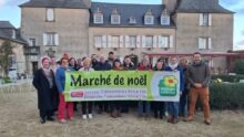 Un groupe tenant une banderole de marché de Noël à la ferme