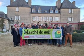 Un groupe tenant une banderole de marché de Noël à la ferme