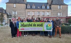 Un groupe tenant une banderole de marché de Noël à la ferme