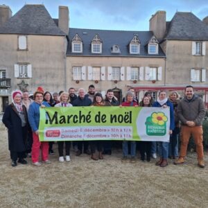 Un groupe tenant une banderole de marché de Noël à la ferme