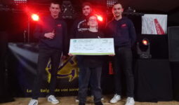 Trois jeunes hommes avec un enfant lors d'une remise de chèque