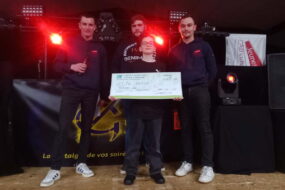 Trois jeunes hommes avec un enfant lors d'une remise de chèque