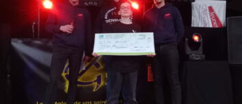 Trois jeunes hommes avec un enfant lors d'une remise de chèque