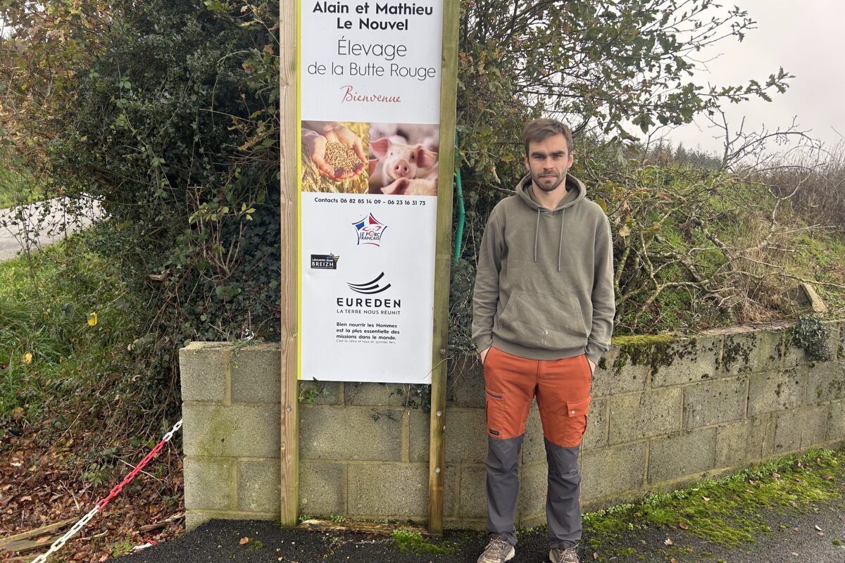 Un homme pose devant la pancarte de son élevage de porc - Illustration L’alimentation Top maximise les performances des porcs