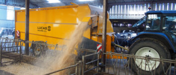 Une pailleuse attelée à un tracteur en train de projeter de la paille sur le côté