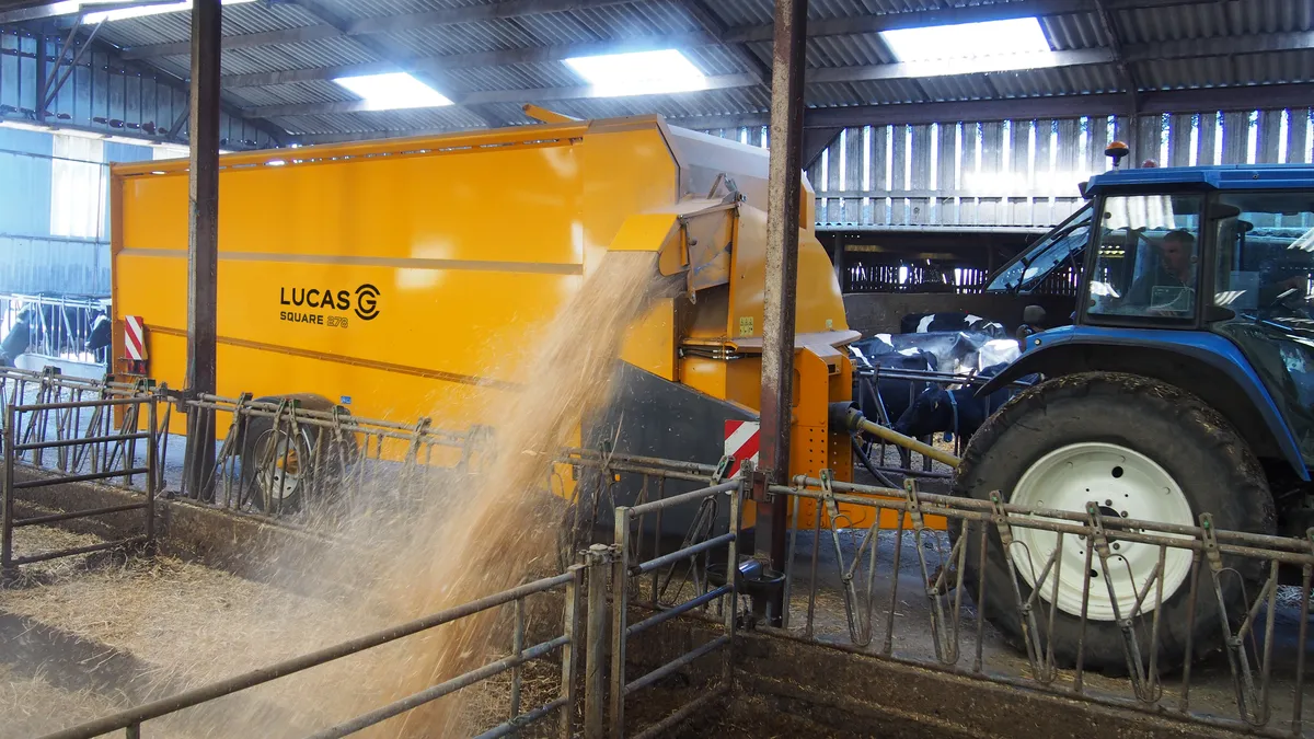 Une pailleuse attelée à un tracteur en train de projeter de la paille sur le côté - Illustration Bien choisir sa pailleuse grand volume