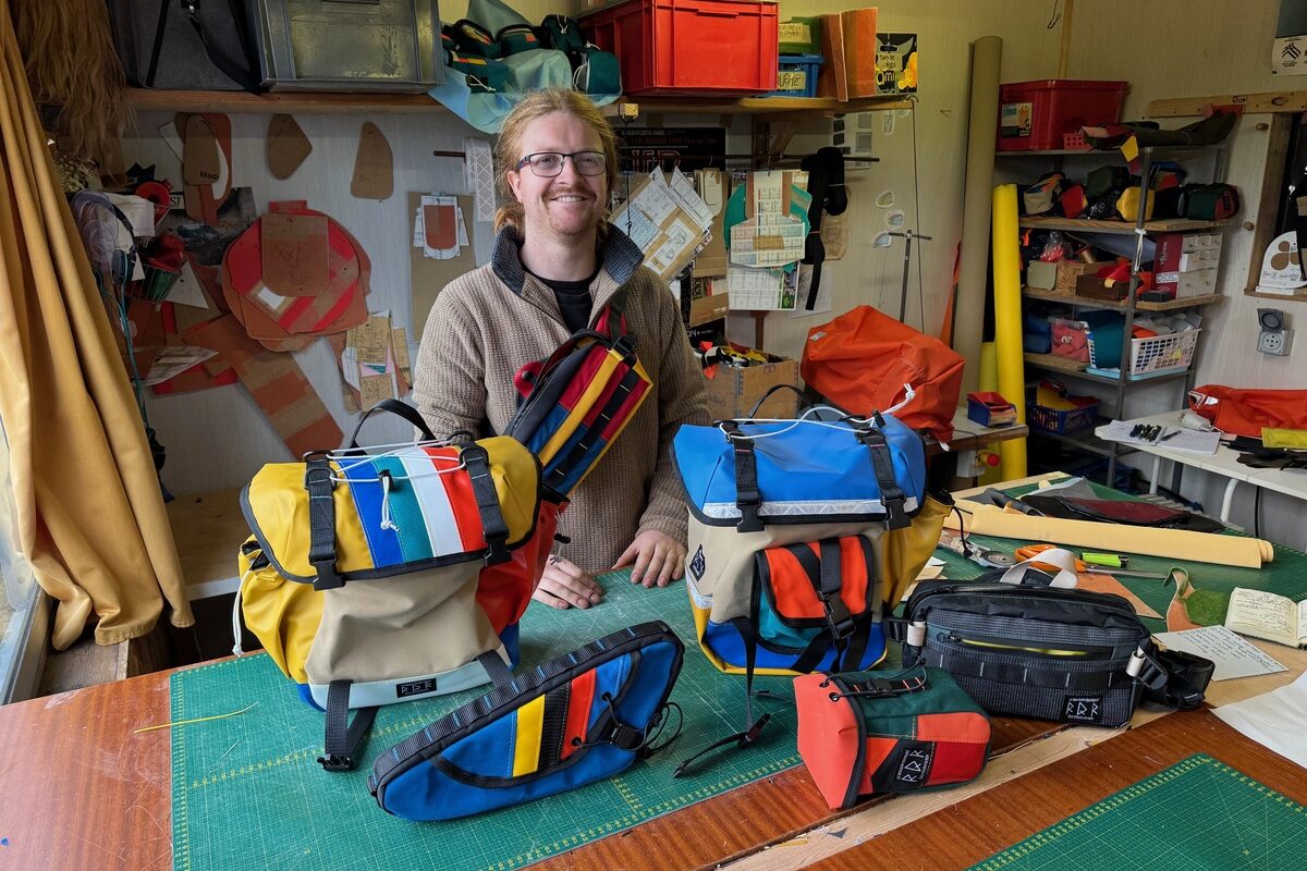Un homme présente ses sacoches pour vélo colorées - Illustration Sacoches locales et originales