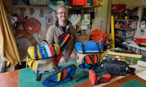 Un homme présente ses sacoches pour vélo colorées